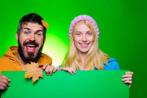 Szczęśliwa para trzyma tablicę reklamową gotową na hasło tekstowe lub jesienną wyprzedaż produktu uśmiechnięta para