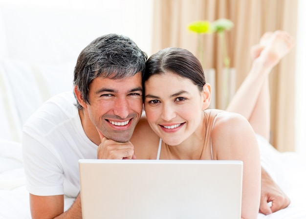 Szczęśliwa para używa laptop