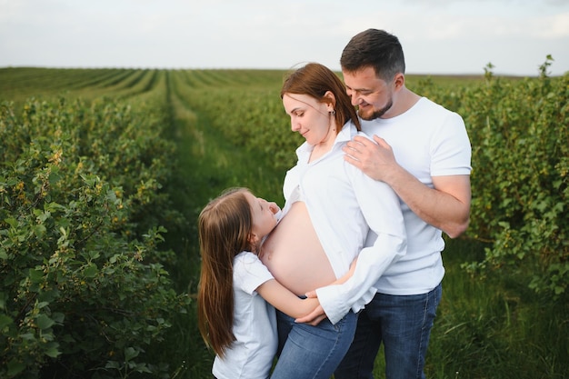 Szczęśliwa para w ciąży z córką w letniej naturze