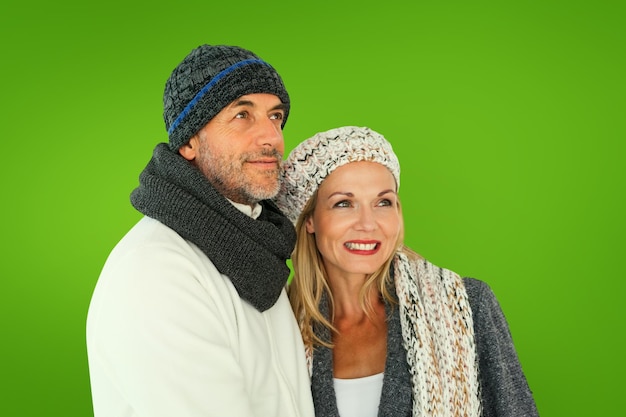 Szczęśliwa para w modzie zimowej, obejmując się przed zieloną winietą