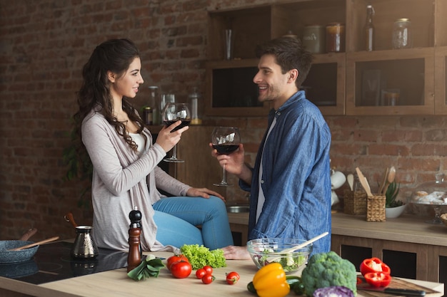 Szczęśliwa para wspólne gotowanie zdrowej żywności i picie wina w ich kuchni na poddaszu w domu. Przygotowanie sałatki warzywnej, rodzinny weekend, miejsce na kopię