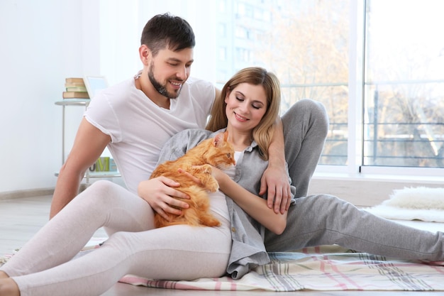Szczęśliwa para z kotem w domu