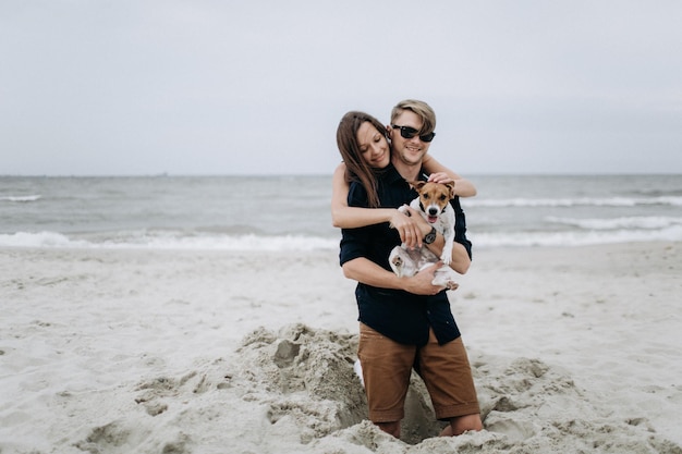 Szczęśliwa para z psem na plaży