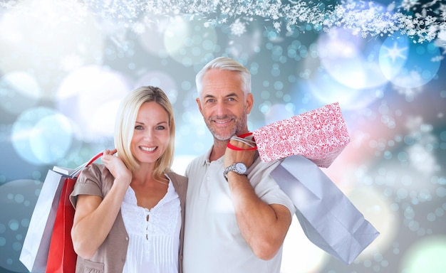 Zdjęcie szczęśliwa para z torbami na zakupy przed lekkimi świecącymi kropkami na niebiesko