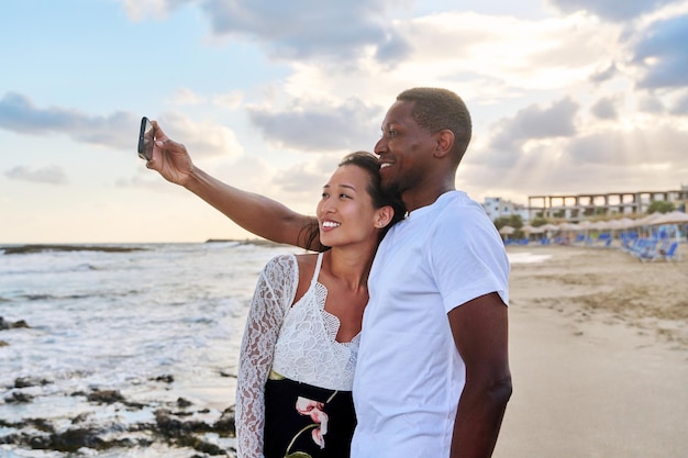 Szczęśliwa para zakochanych biorąc selfie razem na smartfonie na plaży