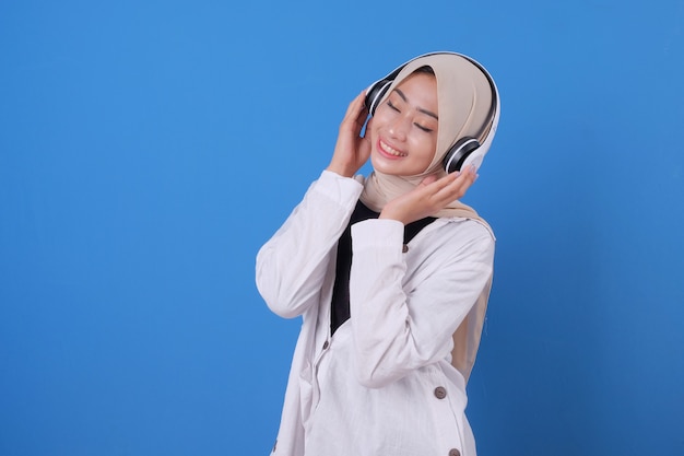 Szczęśliwa piękna dziewczyna słuchania muzyki w słuchawkach bezprzewodowych