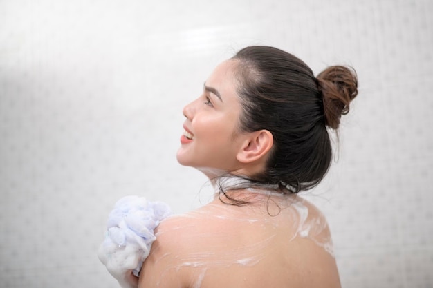 Szczęśliwa piękna kobieta bierze prysznic