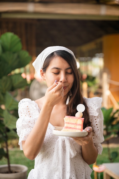 Szczęśliwa Piękna Młoda Azjatykcia Kobieta W Białej Sukni Stojącej Z Pysznym Jedzeniem Ciasta Liczi