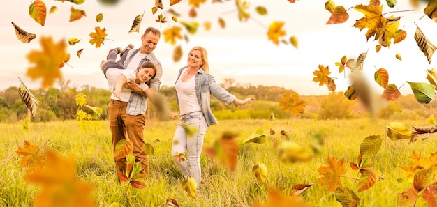 szczęśliwa piękna pięcioosobowa rodzina na spacerze jesienią na tle żółtych liści.