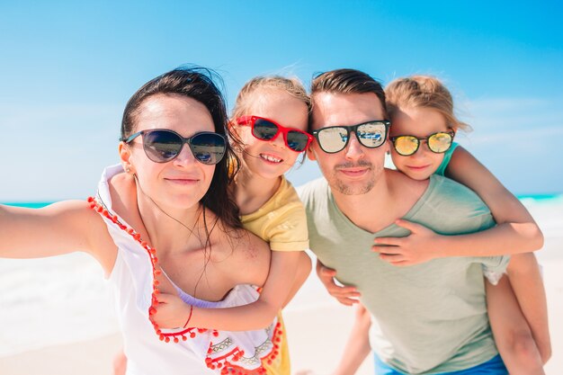 Szczęśliwa piękna rodzina na biel plaży ma zabawę