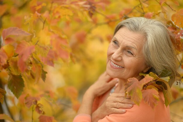 Szczęśliwa piękna starsza kobieta w jesiennym parku