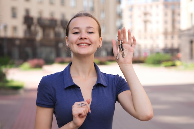 Zdjęcie szczęśliwa pozytywna dziewczyna kupujący młoda uśmiechnięta kobieta trzymająca klucze w ręku nowy właściciel mieszkania lub mieszkania!
