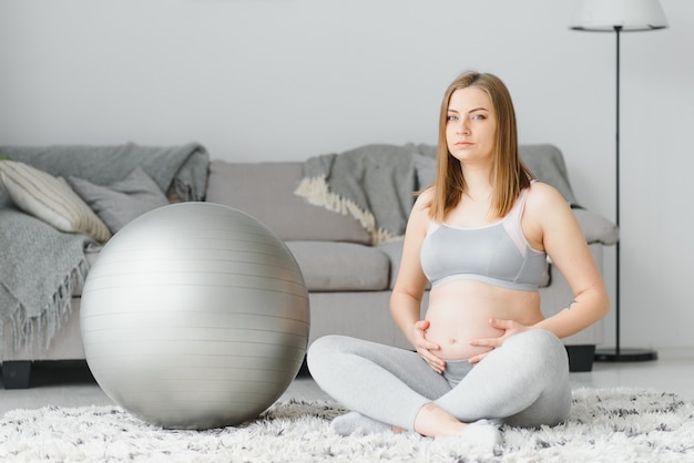 Szczęśliwa przyszła mama robi ćwiczenia pilates