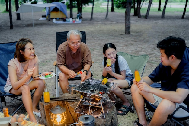 Szczęśliwa Rodzina Azji O Grilla Razem. Gotowanie Grillowanego Grilla Na Kolację Podczas Biwakowania Na Letniej Plaży.