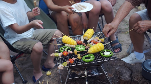 Szczęśliwa Rodzina Azji O Grilla Razem. Gotowanie Grillowanego Grilla Na Kolację Podczas Biwakowania Na Letniej Plaży.