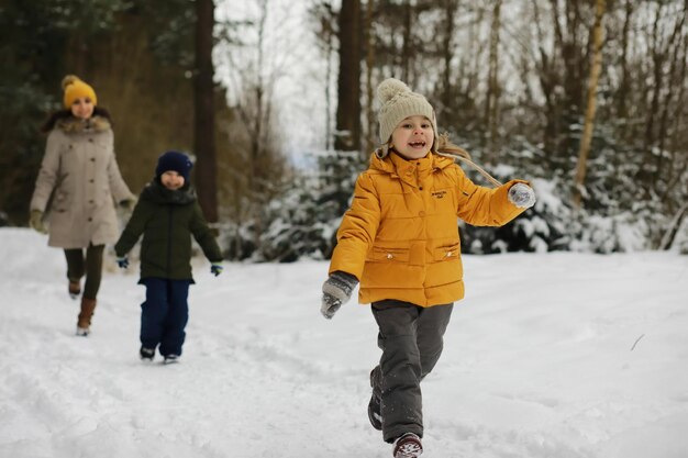 Szczęśliwa rodzina bawi się i śmieje zimą na zewnątrz w śniegu Park miejski zimowy dzień