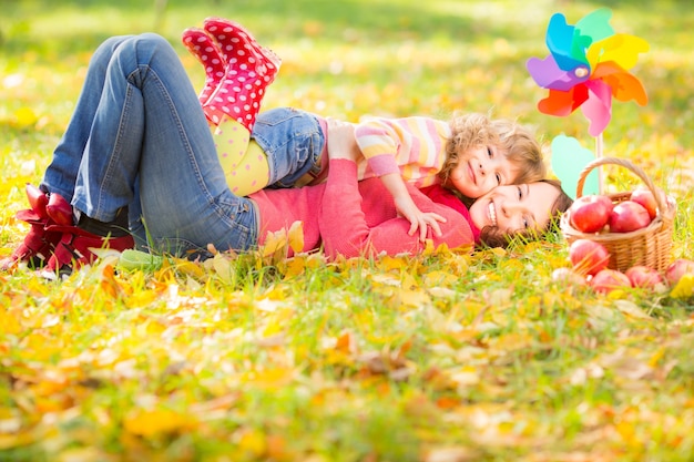 Szczęśliwa rodzina bawi się na świeżym powietrzu w jesiennym parku