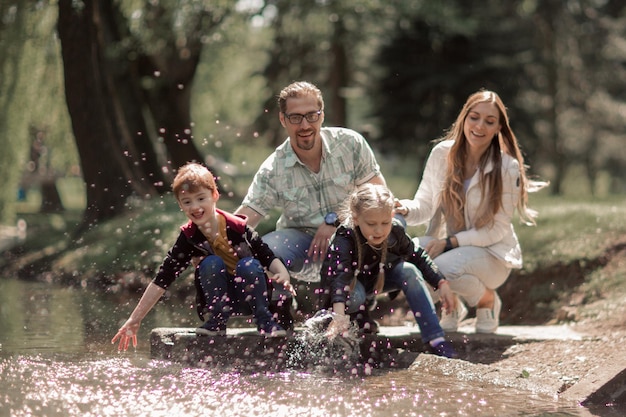 Zdjęcie szczęśliwa rodzina bawi się nad jeziorem