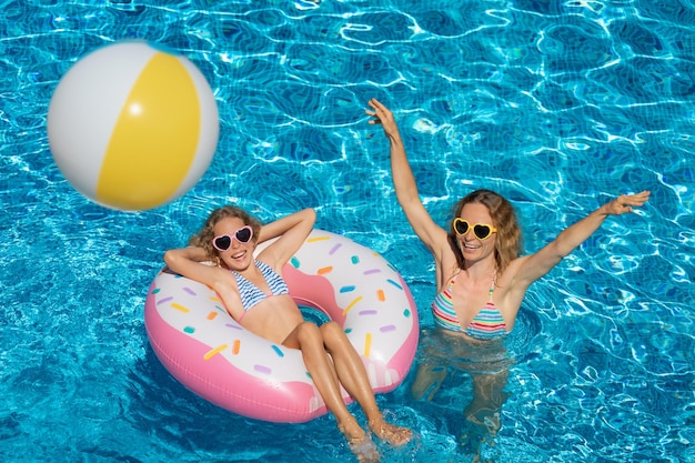 Szczęśliwa rodzina bawi się w odkrytym basenie Ludzie bawią się na wakacjach Koncepcja zdrowego stylu życia