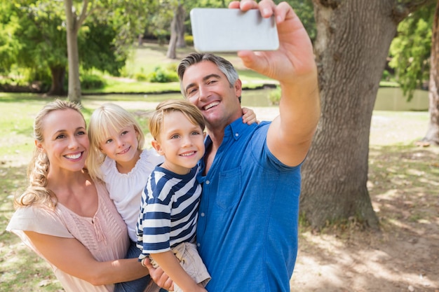Szczęśliwa rodzina bierze selfie w parku