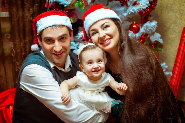 Zdjęcie szczęśliwa rodzina bożego narodzenia z małą córeczką. świąteczny nastrój. nowy rok.