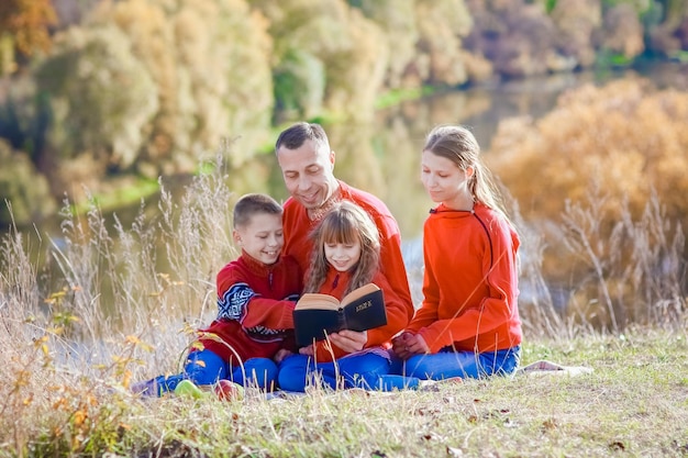Zdjęcie szczęśliwa rodzina czyta książkę biblia w rodzinie koncepcyjnej natury