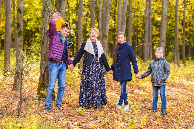 szczęśliwa rodzina gra z jesiennych liści w parku