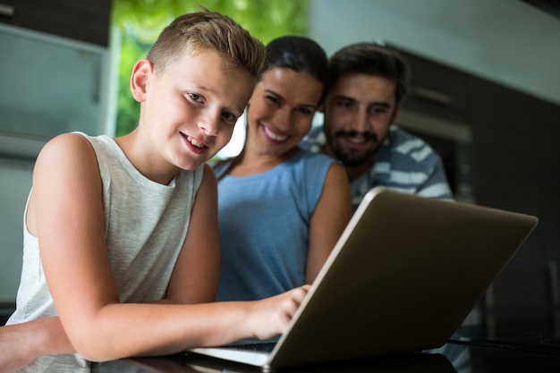 Zdjęcie szczęśliwa rodzina korzysta z laptopa w salonie