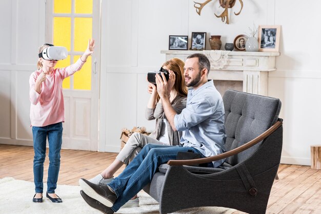 Szczęśliwa rodzina korzystająca z zestawów słuchawkowych do wirtualnej rzeczywistości w domu