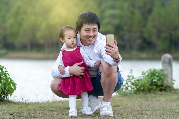 Szczęśliwa rodzina która azjatykci ojciec z córki brać