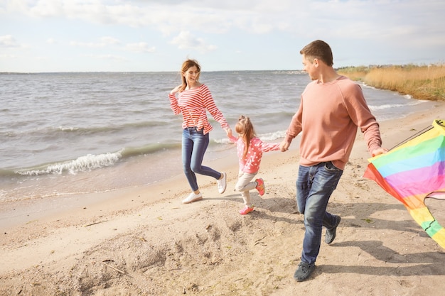 Szczęśliwa rodzina latający latawiec w pobliżu rzeki