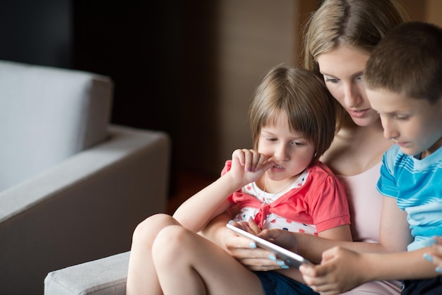 Szczęśliwa Rodzina Leżąc Na Kanapie I Za Pomocą Tabletu