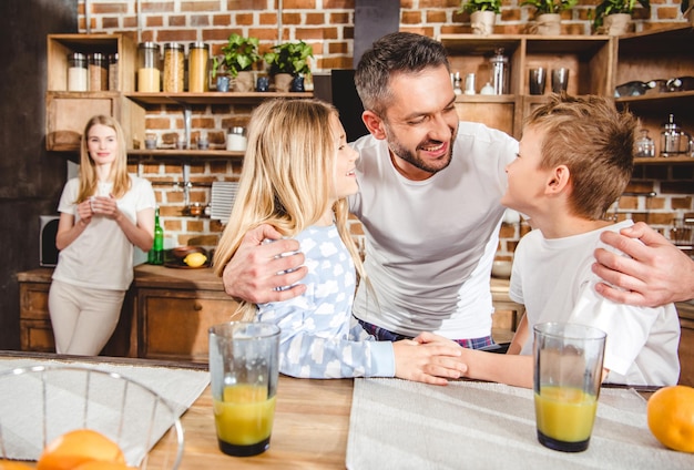 Zdjęcie szczęśliwa rodzina ma świeży sok pomarańczowy na śniadanie w kuchni