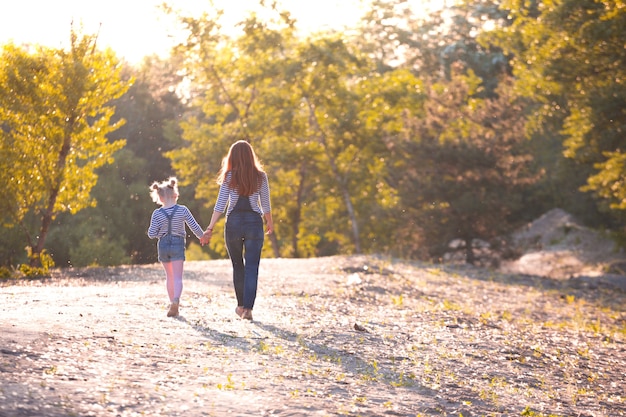 Szczęśliwa rodzina - mama i córka na spacerze o zachodzie słońca