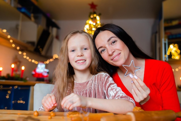 Szczęśliwa rodzina mama i córka pieczą ciasteczka na Boże Narodzenie