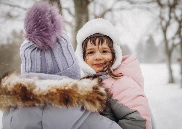 Szczęśliwa rodzina matka i córka bawią się na zimowy spacer na świeżym powietrzu. zimowy portret matki i dziecka.