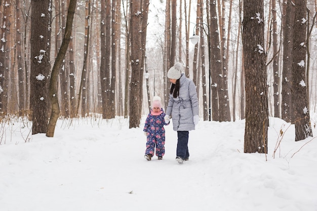Szczęśliwa rodzina matka i córka córka zabawy, grając na spacer zimą na świeżym powietrzu