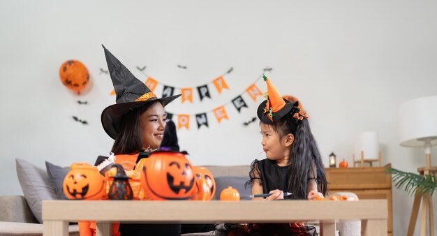 Szczęśliwa rodzina matka i dziecko szczęśliwa dziewczyna z Halloween w domu razem pięknie ozdobione