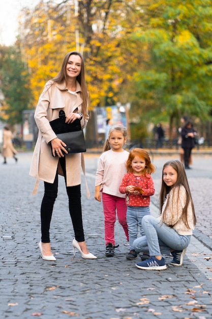 Szczęśliwa rodzina. matka trzech córek dziecko dziewczynka razem, przytulanie i radosny śmiech, relaksując się w parku na wakacjach. Rodzinny styl życia na świeżym powietrzu.