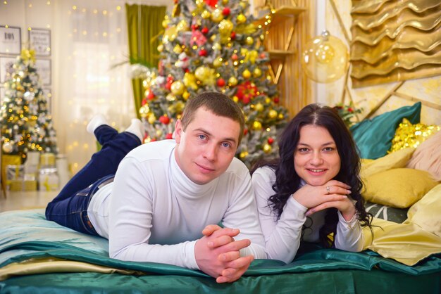 szczęśliwa rodzina mąż i żona w pięknych ubraniach razem w domu na Boże Narodzenie