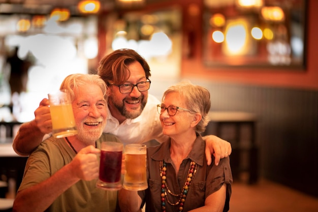 Szczęśliwa rodzina, mieszane pokolenia, dorośli i starsi seniorzy cieszą się wspólnym świętowaniem, brzęczącym piwem w pubie restauracyjnym i szukaniem ładnego zdjęcia