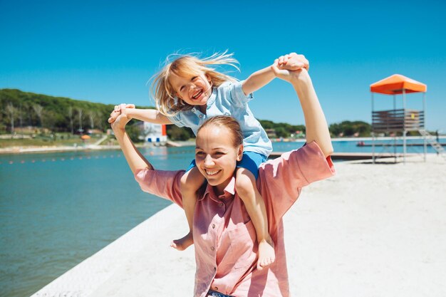 Szczęśliwa rodzina Młoda piękna mama i jej syn bawią się na plaży emocje uczucia radość