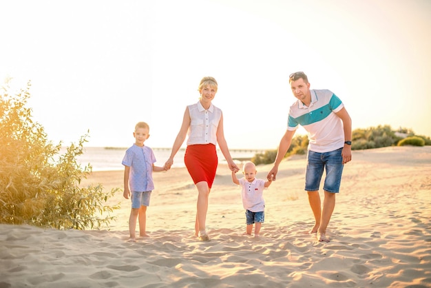 Szczęśliwa rodzina na plaży wśród wydm Rodzina z dwójką małych synów