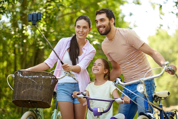 szczęśliwa rodzina na rowerze robiąca selfie latem