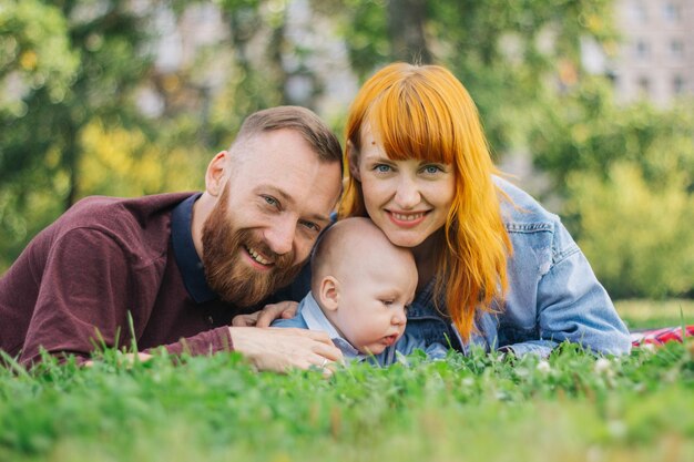 Zdjęcie szczęśliwa rodzina odpoczywa na koce nad trawą