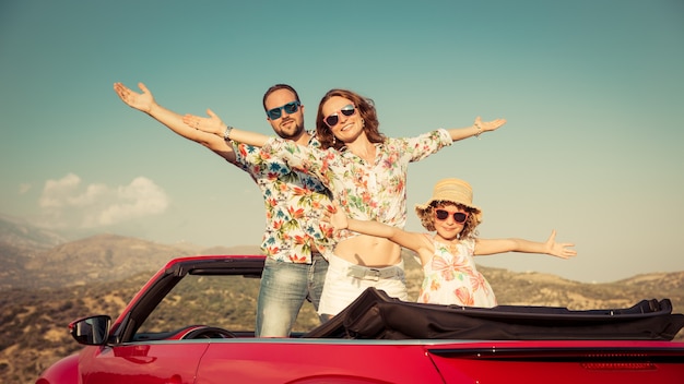 Szczęśliwa rodzina podróż samochodem w górach Ludzie bawią się w czerwonym kabriolecie Koncepcja wakacji letnich
