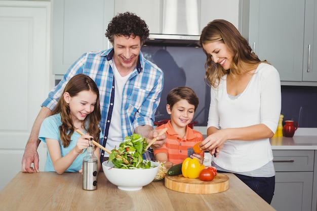 Szczęśliwa rodzina przygotowuje sałatka jarzynowa