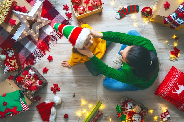 Szczęśliwa rodzina przygotowuje się do Bożego Narodzenia. Matka i córka dekorują dom na wakacje.