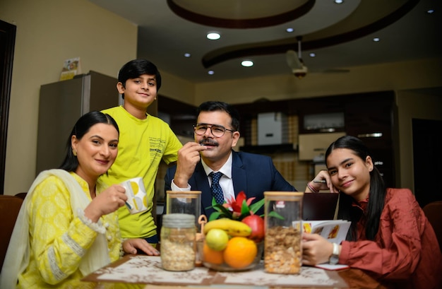 szczęśliwa rodzina siedzi na stole indyjski model pakistański