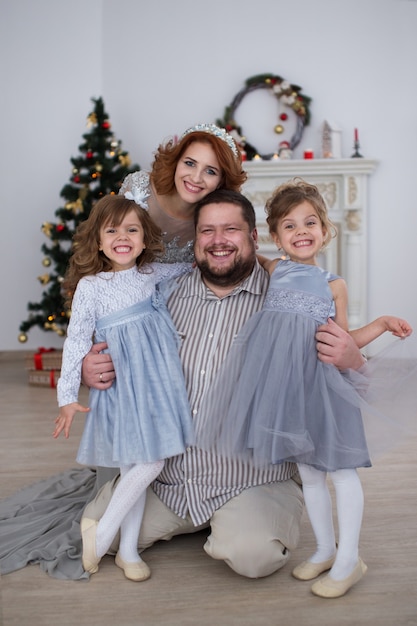 szczęśliwa rodzina siedzi przy choince